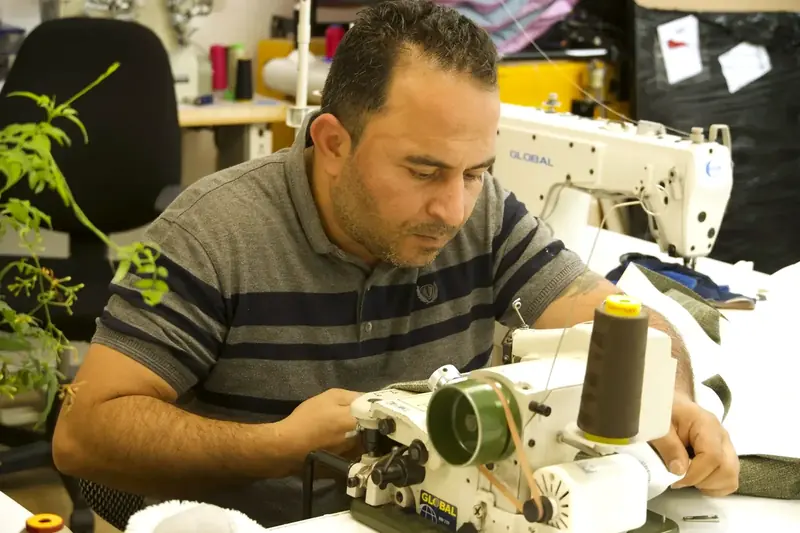 Lazki Isso aan het werk achter de naaimachine