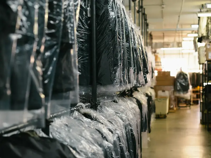 Gereinigde kleding in hoezen aan het rek